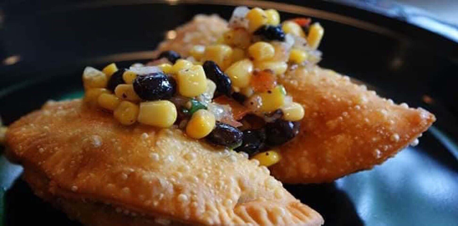 Golden empanadas topped with corn and black bean salsa